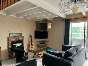 a living room with a couch and a fireplace at Maison en pierre in Trémeven