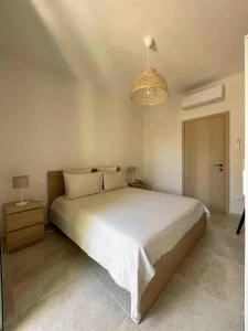 a bedroom with a large white bed and a chandelier at Casa Rosalia in Cozze