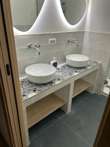 a bathroom with two sinks on a counter with a mirror at Casa Rosalia in Cozze