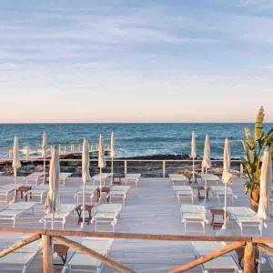 a group of chairs and umbrellas on the beach at Casa Rosalia in Cozze