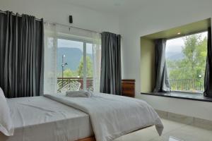 a bedroom with a bed and a large window at Banbury Bungalow in Kanthalloor