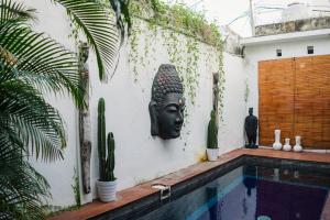 a wall with a statue of a head next to a swimming pool at Private-Pool Family Villa near Canggu Beach in Tumbak Bayuh