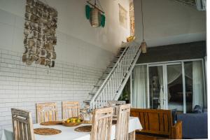 a dining room with a table with chairs and a staircase at Private-Pool Family Villa near Canggu Beach in Tumbak Bayuh +25 photos