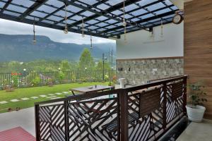 a balcony with a table and a view of a garden at Banbury Bungalow in Kanthalloor