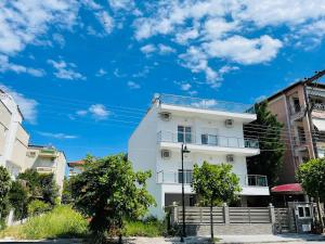 a white building with a blue sky in the background at ApartHotel Villa Eva 1 bedroom in Olympiaki Akti