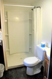 Un baño blanco con inodoro y ducha. en Authentic Log Cabin with a Deck in Chugach National Forest, Alaska, en Cooper Landing