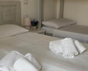 two white towels are sitting on top of a bed at Casa Brezza Marina - Appartamento Brezza in Torre Lapillo