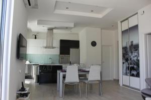 eine Küche mit einem Esstisch und weißen Stühlen in der Unterkunft Apartment Jadranka in Split