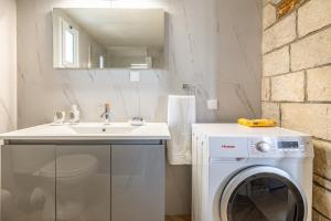 a bathroom with a washing machine and a sink at Elea Home in Goúrnes