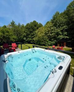 a jacuzzi tub on a deck with trees in the background at Mátramélye Vendégház in Parád