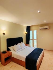 سرير أو أسرّة في غرفة في Kush Hotel, Grand Museum & Pyramids View