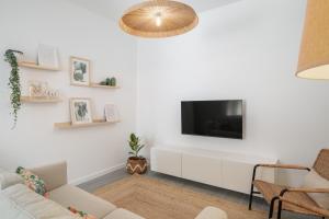 a living room with a tv on a white wall at Barlavento by An Island Apart in Porto Santo