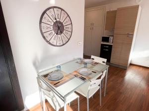 a dining room with a table and a clock on the wall at Monolocale in Asti Centro in Palazzo storico 30min da Alba Fiera del Tartufo in Asti