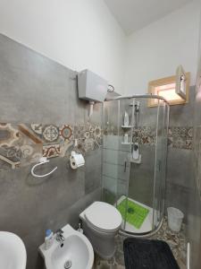 a bathroom with a shower and a toilet and a sink at Casa Brezza Marina - Appartamento Brezza in Torre Lapillo +14 photos