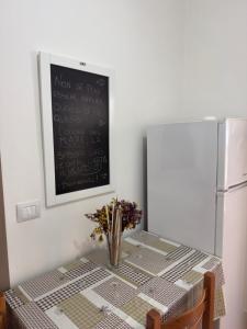 a table with a vase of flowers and a chalkboard at Casa Brezza Marina - Appartamento Brezza in Torre Lapillo