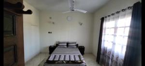 two beds in a room with a window at Hôtel CONTINENTAL in Morondava