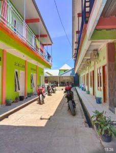 un grupo de motocicletas estacionadas en una calle al lado de los edificios en Penginapan Herlandy, en Komodo Labuan Bajo Airport