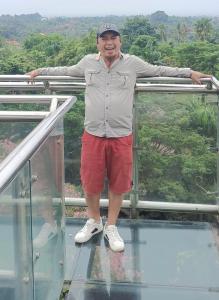 Un hombre de pie sobre un piso de vidrio. en Penginapan Herlandy, en Komodo Labuan Bajo Airport