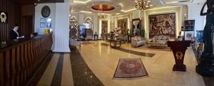 a lobby of a hotel with a person standing at a counter at Hyksos Hotel in Erbil