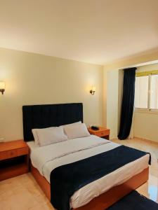 سرير أو أسرّة في غرفة في Kush Hotel, Grand Museum & Pyramids View