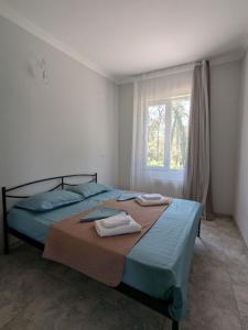 a bedroom with a bed with towels on it at Nino apartments in Ureki