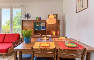 a dining room with a table and a red couch at Charmante Maison Proche Plage in Vaux-sur-Mer