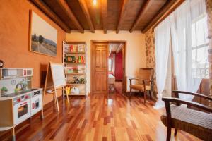 un soggiorno con pavimento in legno massello e una cucina di La Casa del Médico a Cerezo de Abajo