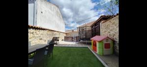 un cortile con una cuccia per cani sul lato di un edificio di La Casa del Médico a Cerezo de Abajo