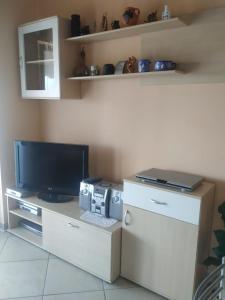 a living room with a tv and a computer on a desk at Apartman Andrija Polje in Polje