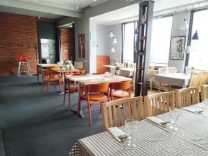 a dining room with tables and chairs and windows at Bed&Breakfast Mikunda in Chrzanów
