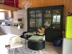 una cucina con tavolo in vetro e sedie di Le Chalet de PiqueyRote a Hourtin