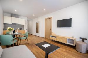a living room with a dining table and a television at Blue Sky Apart-Hotel Batumi in Batumi