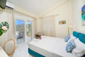 a bedroom with a bed and a large window at INROY SEA VIEW APARTMENTS in Skala Potamias