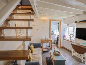 ein Wohnzimmer mit Sofa und Fernseher in der Unterkunft Cleve Cottage in Lyme Regis