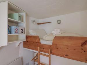 ein kleines Zimmer mit einem Bett und einem Regal in der Unterkunft Cleve Cottage in Lyme Regis