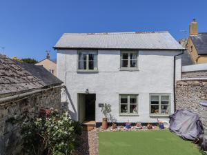 ein weißes Haus mit grünem Rasen davor in der Unterkunft Cleve Cottage in Lyme Regis