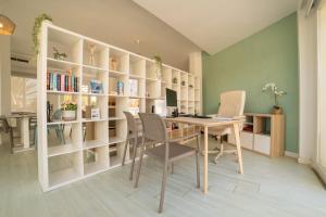 a home office with a desk and chairs and bookshelves at Apartamentos Azul Playa in Cala d´Or