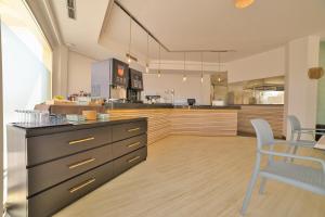 a kitchen with a counter and a table and chairs at Apartamentos Azul Playa in Cala d´Or
