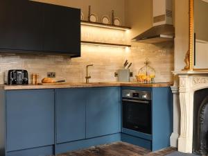 a kitchen with blue cabinets and a stove at Bijou Beauty - Bath Abbey in Bath