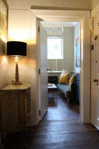 a living room with a couch and a lamp on a table at Bijou Beauty - Bath Abbey in Bath