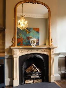 a fireplace with a large mirror above it at Bijou Beauty - Bath Abbey in Bath +17 photos