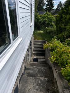 a set of stairs next to a house with a window at Cozy apartment in quiet neighborhood in Oslo +1 photo