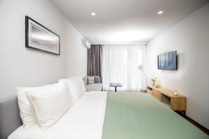 a hotel room with a white bed and a window at Blue Sky Apart-Hotel Batumi in Batumi +41 photos