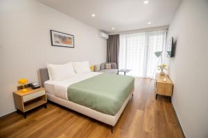 a hotel room with a bed and a chair at Blue Sky Apart-Hotel Batumi in Batumi +47 photos