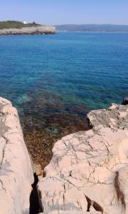 a view of a body of water with rocks at B&B La Casa Bianca di Porto Conte in Porto Conte