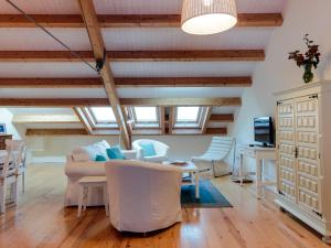 a living room with white furniture and wooden ceilings at Casa Azul do Cais in São Martinho do Porto