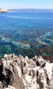 a view of the ocean with rocks and water at B&B La Casa Bianca di Porto Conte in Porto Conte