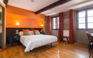 a bedroom with a large bed with orange walls at Hotel Alda Algalia in Santiago de Compostela
