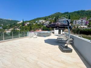 a patio with an umbrella and lounge chairs on a roof at Flabelline Apartments in Bar