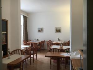 un comedor con mesas y sillas y una habitación sin ascensor en Pension Ani-Falstaff, en Viena